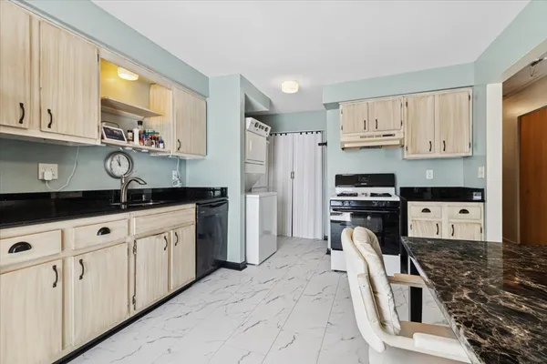 a kitchen with granite countertop a sink a counter space appliances and cabinets