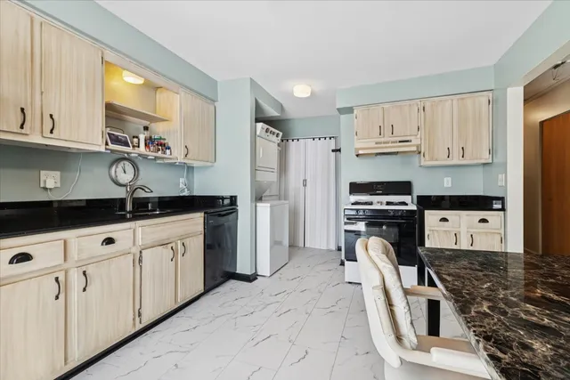 a kitchen with granite countertop a sink a counter space appliances and cabinets