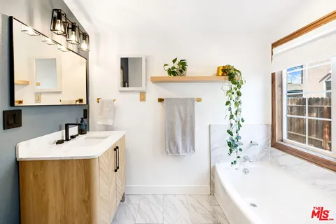 a bathroom with a tub sink and mirror