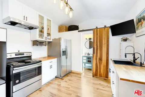 a kitchen with stainless steel appliances granite countertop a refrigerator and a stove top oven