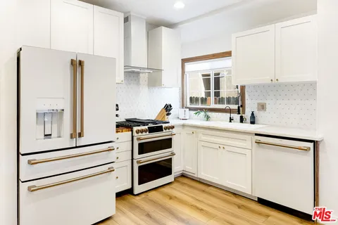 a kitchen with white cabinets and white appliances