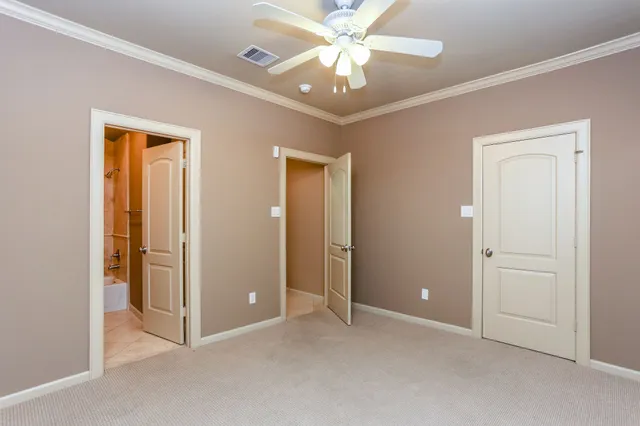 an empty room with closet and a chandelier fan