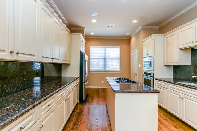 a kitchen with granite countertop a sink a stove and cabinets
