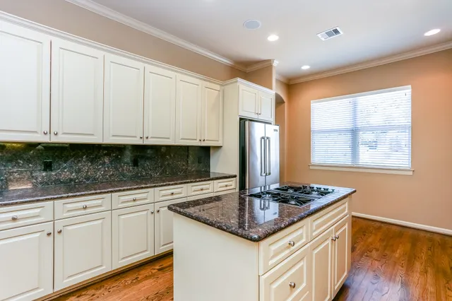 a kitchen with stainless steel appliances granite countertop a stove a sink and a refrigerator