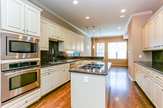 a kitchen with stainless steel appliances kitchen island granite countertop a stove a sink and a microwave