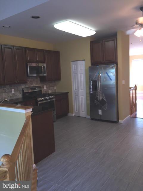27 Bank Spring Court Owings Mills, MD 21117 - Photo 13 of 27 a kitchen with stainless steel appliances granite countertop a refrigerator and a sink