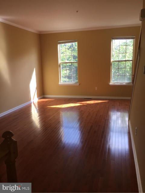 27 Bank Spring Court Owings Mills, MD 21117 - Photo 7 of 27 an empty room with wooden floor and windows
