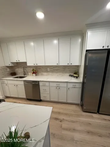 a kitchen with stainless steel appliances a refrigerator sink and cabinets