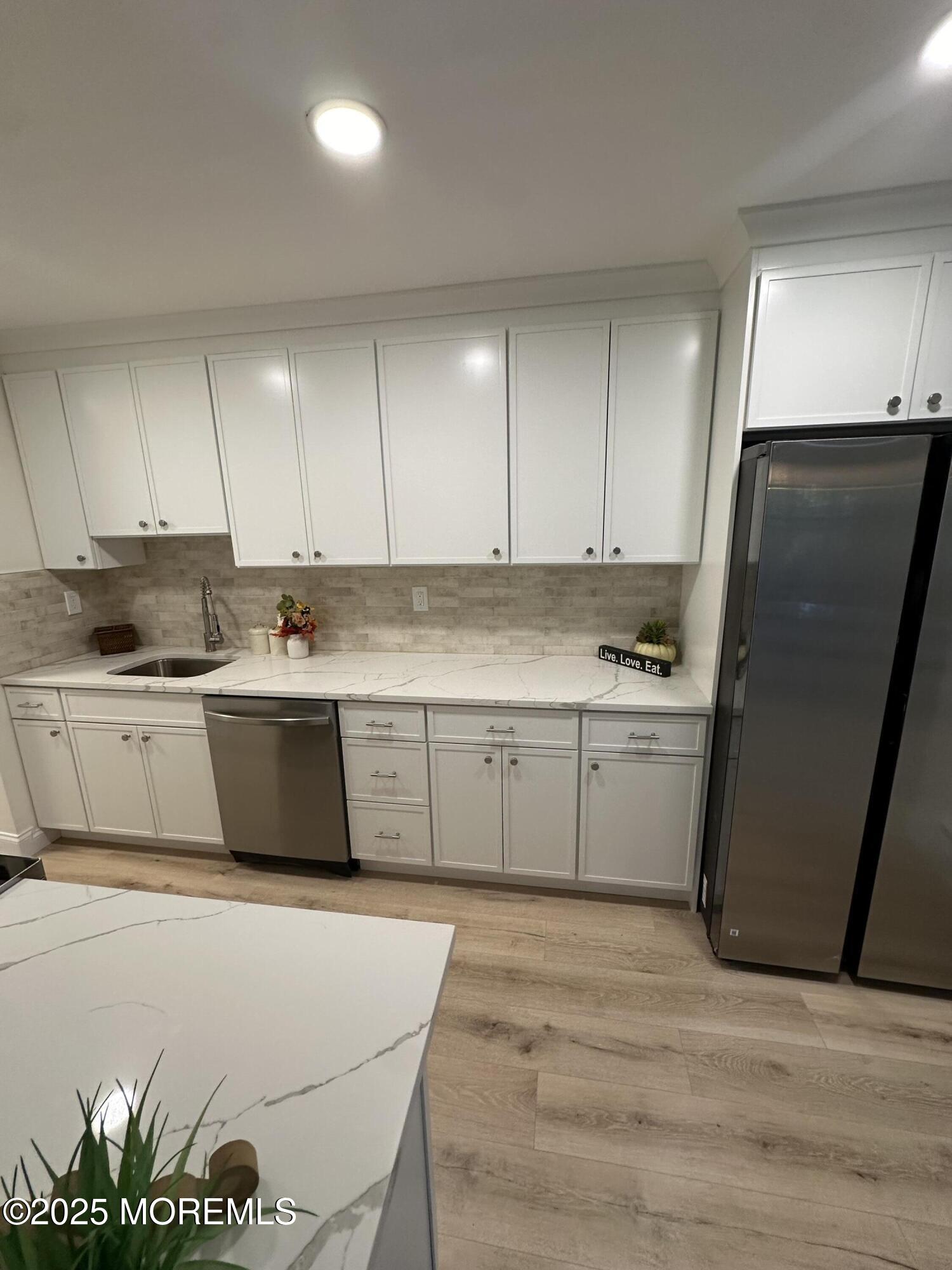 a kitchen with stainless steel appliances a refrigerator sink and cabinets