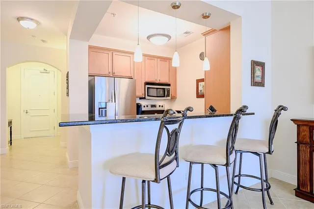 a dining room with stainless steel appliances a refrigerator and a fireplace