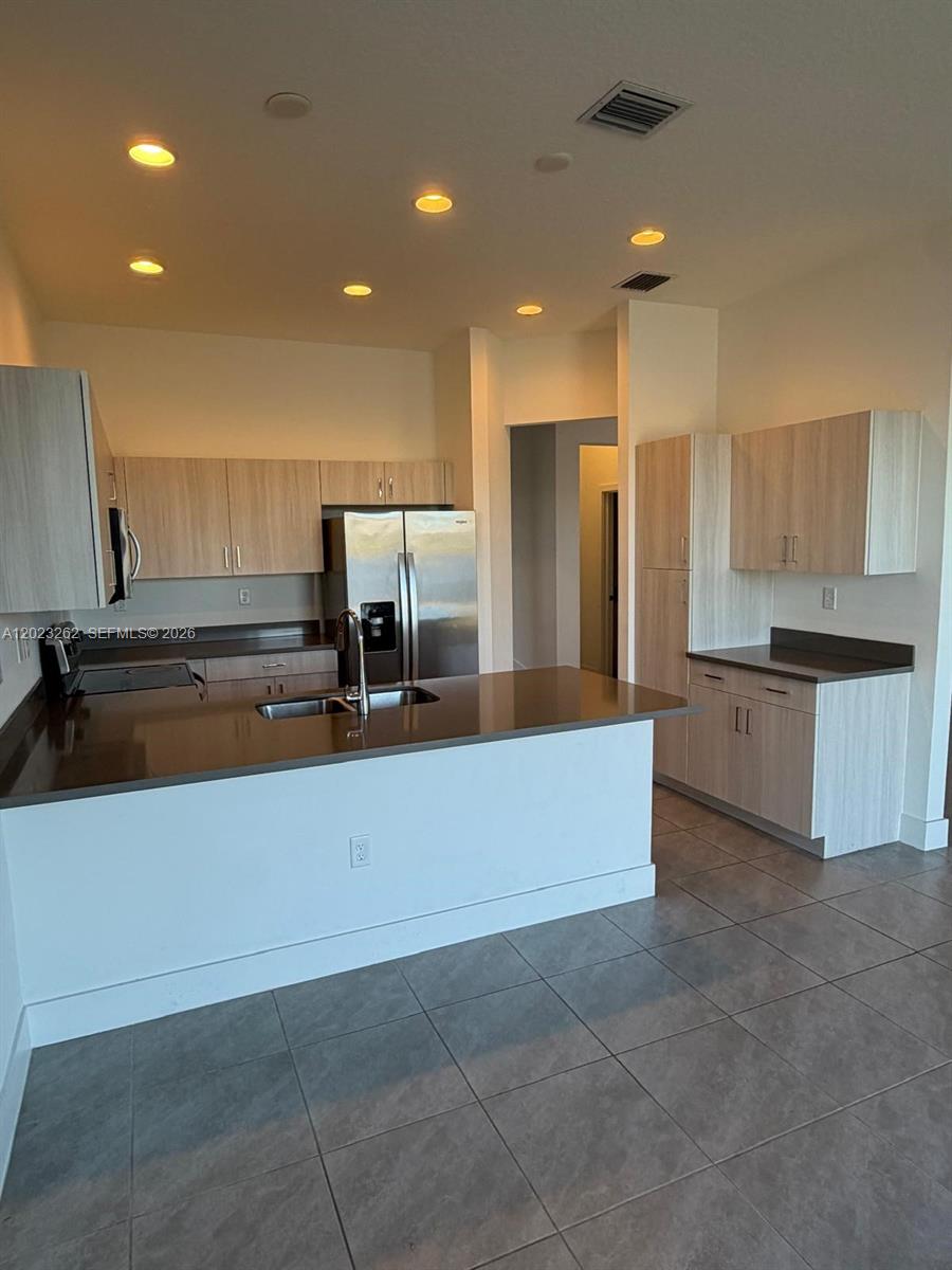 5669 Cerva Lane, Unit 5669 Immokalee, FL 34142 - Photo 6 of 32 a kitchen with kitchen island a counter top and appliances