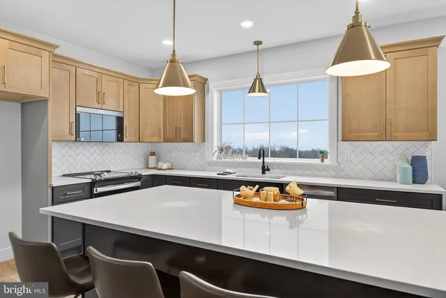 a kitchen with a sink dishwasher a stove a dining table and chairs with wooden floor