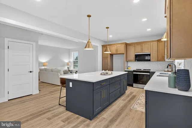 a large kitchen with stainless steel appliances a sink a stove and cabinets