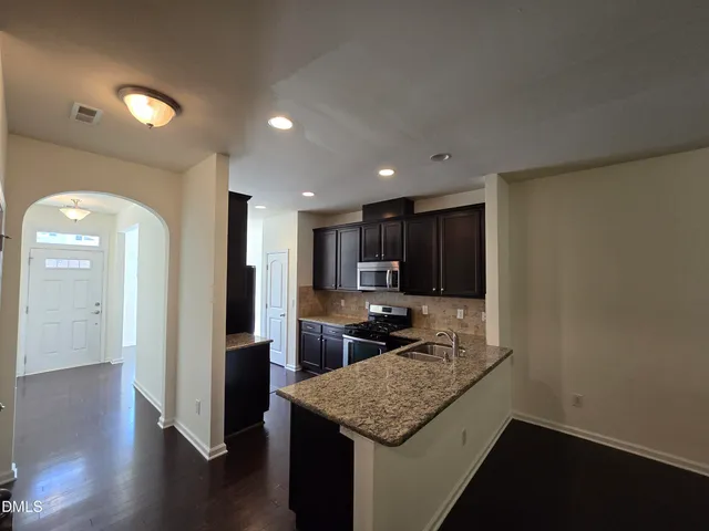 a kitchen with stainless steel appliances granite countertop a sink and a stove