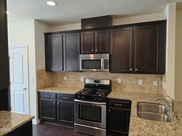 a kitchen with a sink stove and refrigerator