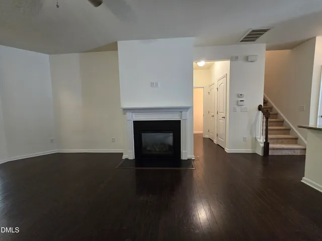 a view of a livingroom with wooden floor and a fireplace