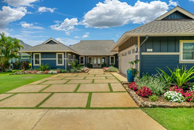 a front view of a house with a yard and potted plants