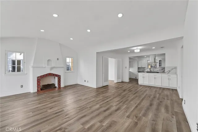 a view of empty room with wooden floor and fireplace