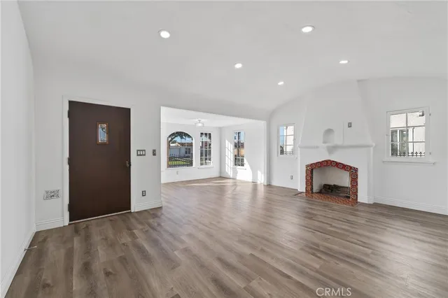 a view of empty room with wooden floor and window