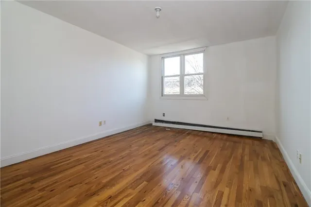 a view of a room with wooden floor and window