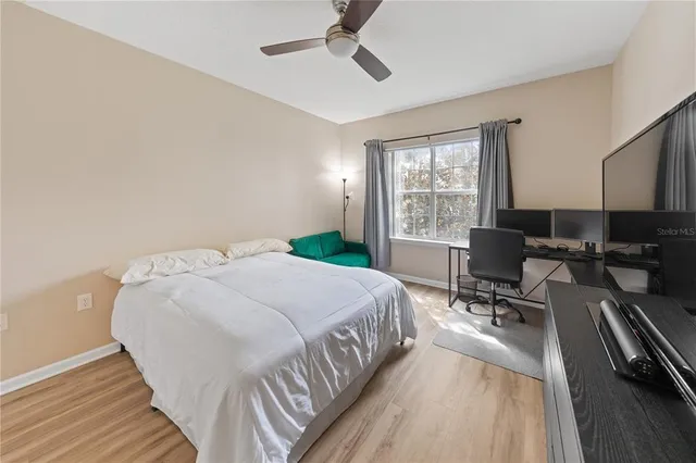 a bedroom with a bed a chair and a large window