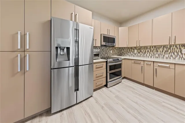 a kitchen with stainless steel appliances a refrigerator sink and microwave