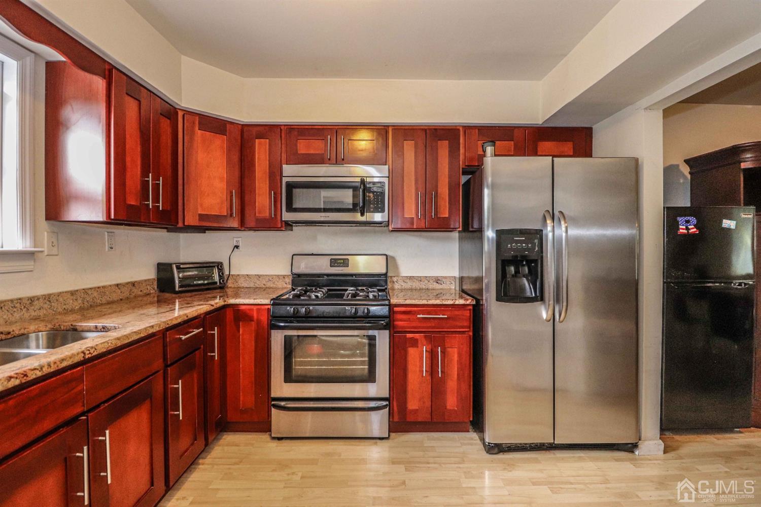 24 Redbud Road Piscataway, NJ 08854 - Photo 7 of 32 a kitchen with stainless steel appliances granite countertop a stove a refrigerator and a sink