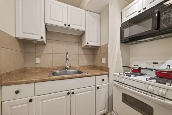 a kitchen with stainless steel appliances granite countertop white cabinets sink and dishwasher