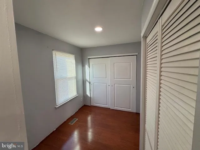 a view of empty room with window and wooden floor