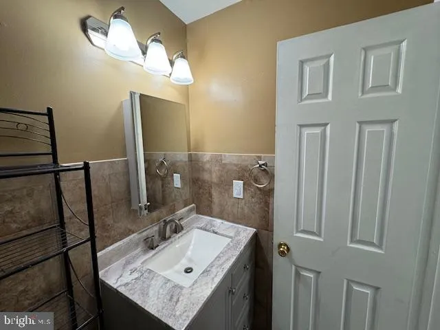 a bathroom with a sink a light fixture and a mirror