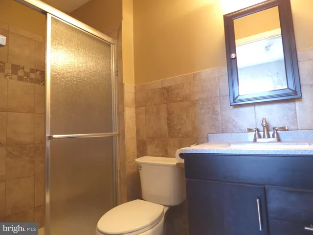 a bathroom with a sink a toilet a mirror and shower