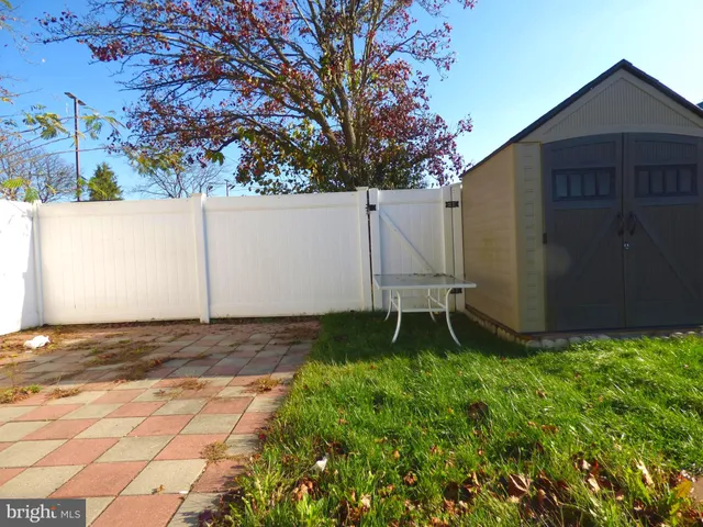 a backyard of a house with lawn chairs and a stove