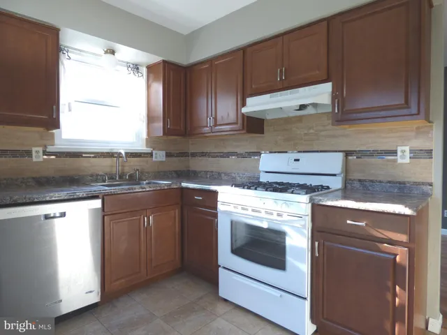 a kitchen with granite countertop cabinets stainless steel appliances and sink