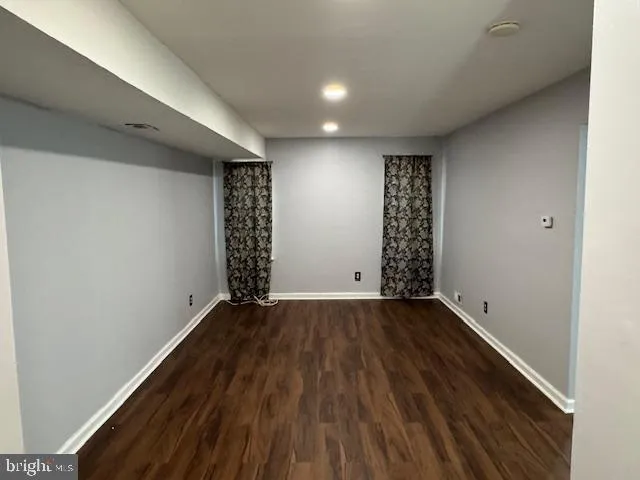 a view of an empty room with wooden floor and entryway