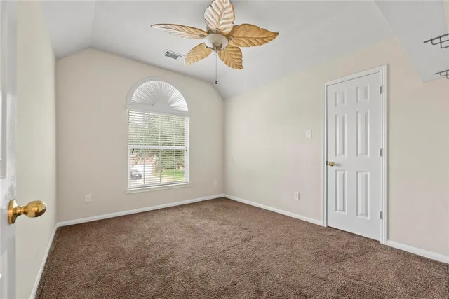 an empty room with a window and a fan