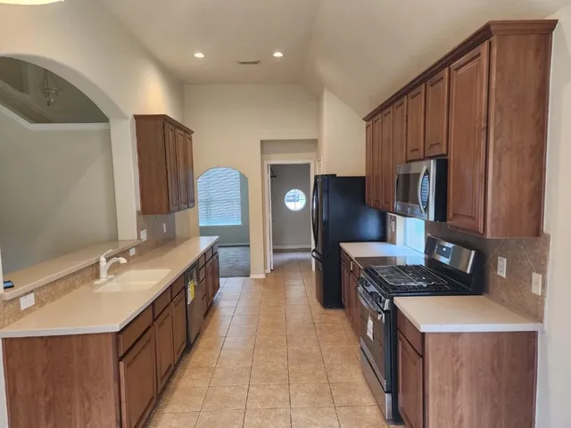 a kitchen with sink stove and refrigerator