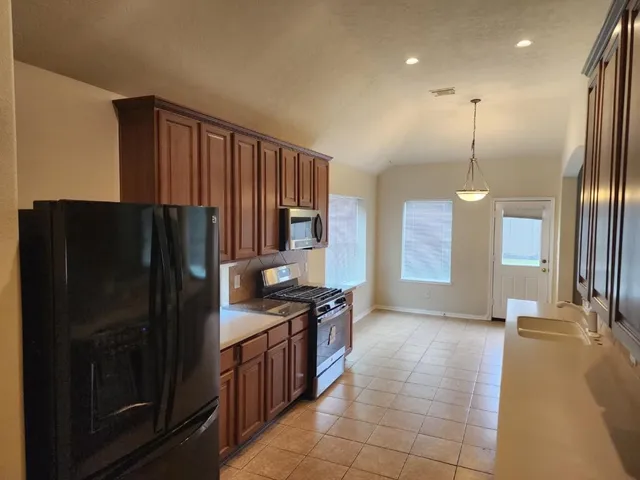 a kitchen with stainless steel appliances granite countertop a refrigerator and a sink