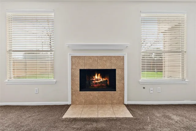 an empty room with a fireplace and windows