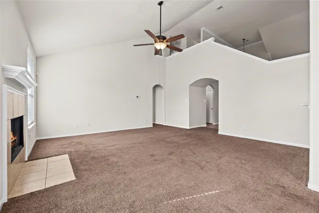a view of a livingroom with a ceiling fan and kitchen view