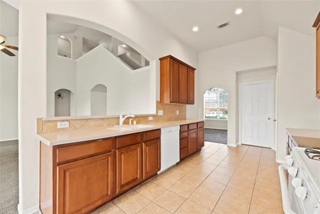 a spacious bathroom with a granite countertop sink a mirror and a bathtub