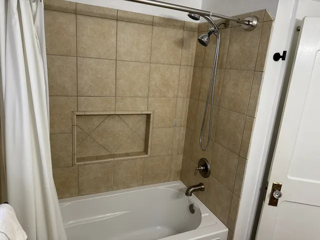 a bathroom with a shower and a bath tub
