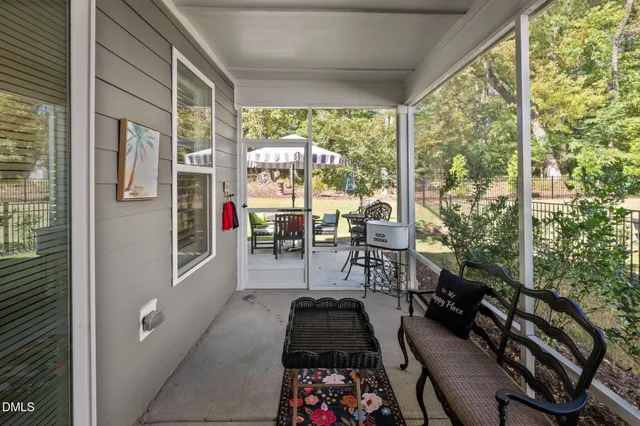 a view of a patio with table and chairs with wooden floor and fence
