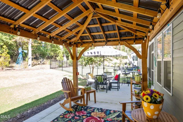 a view of a patio with a table and chairs under an umbrella