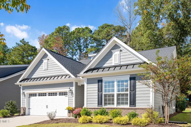 a view of a house with a yard and potted plants