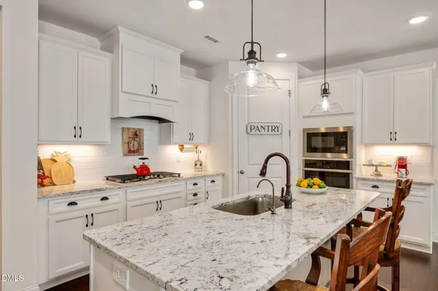 a kitchen with stainless steel appliances granite countertop a stove a sink a refrigerator and a stove