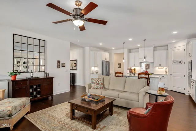 a living room with furniture kitchen view and a window
