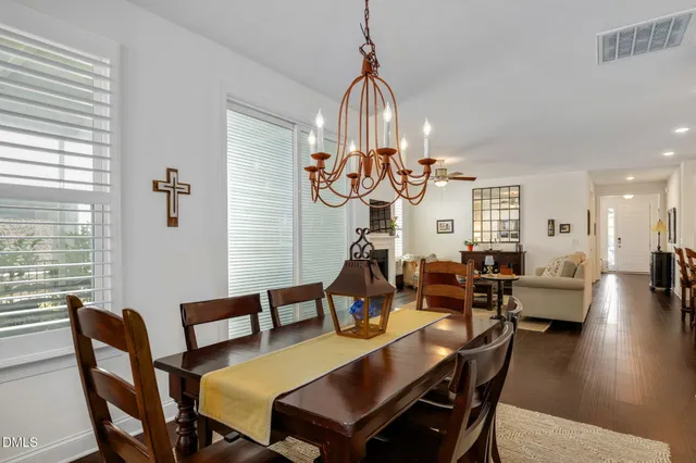 a view of a dining room and livingroom with furniture wooden floor a chandelier