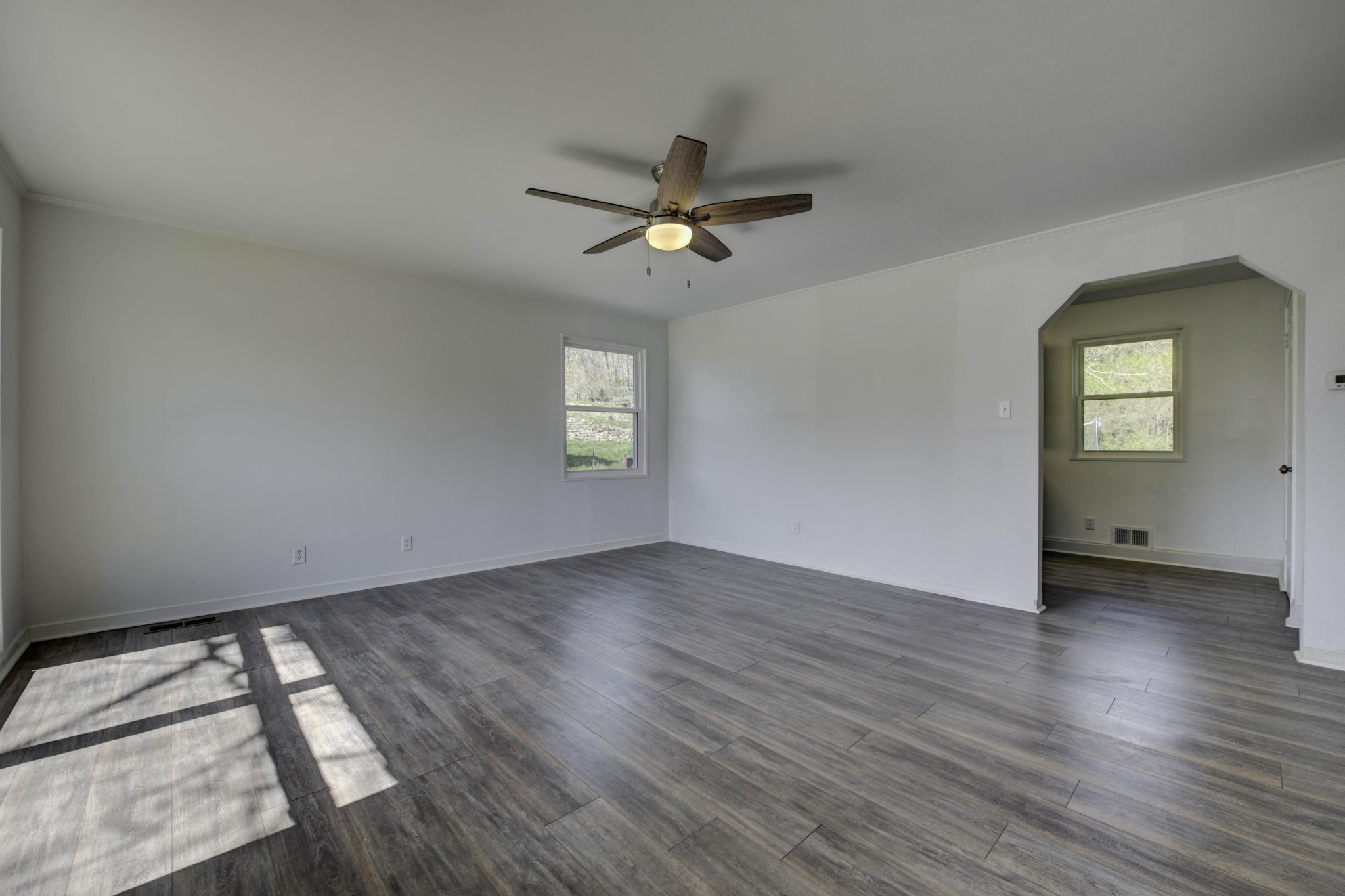 119 Alger Road Oak Ridge, TN 37830 - Photo 4 of 22 an empty room with wooden floor chandelier fan and windows
