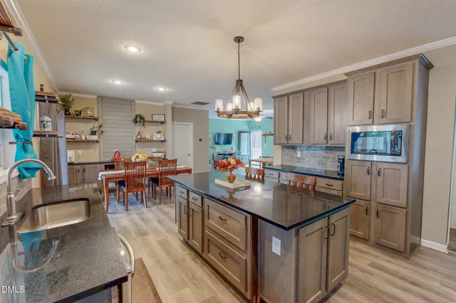 a kitchen that has a lot of cabinets a sink and appliances in it