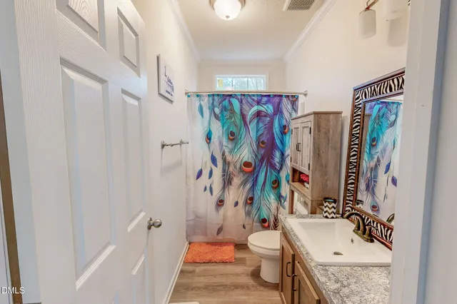 a view of a livingroom with furniture a bookshelf wooden floor and a window